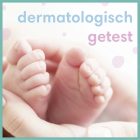 Babyvoetjes zacht vastgehouden in de handen van een volwassene met de tekst 'dermatologisch getest'.