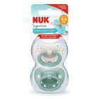 "NUK Signature siliconen fopspeen set in verpakking, voor 0-6 maanden, met een kleurrijk sterren- en stippenpatroon en een effen zeegroen ontwerp.