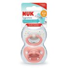 NUK Signature siliconen fopspeen set in verpakking, voor 0-6 maanden, met een speels stippen- en sterrenpatroon en een effen zalmroze ontwerp.